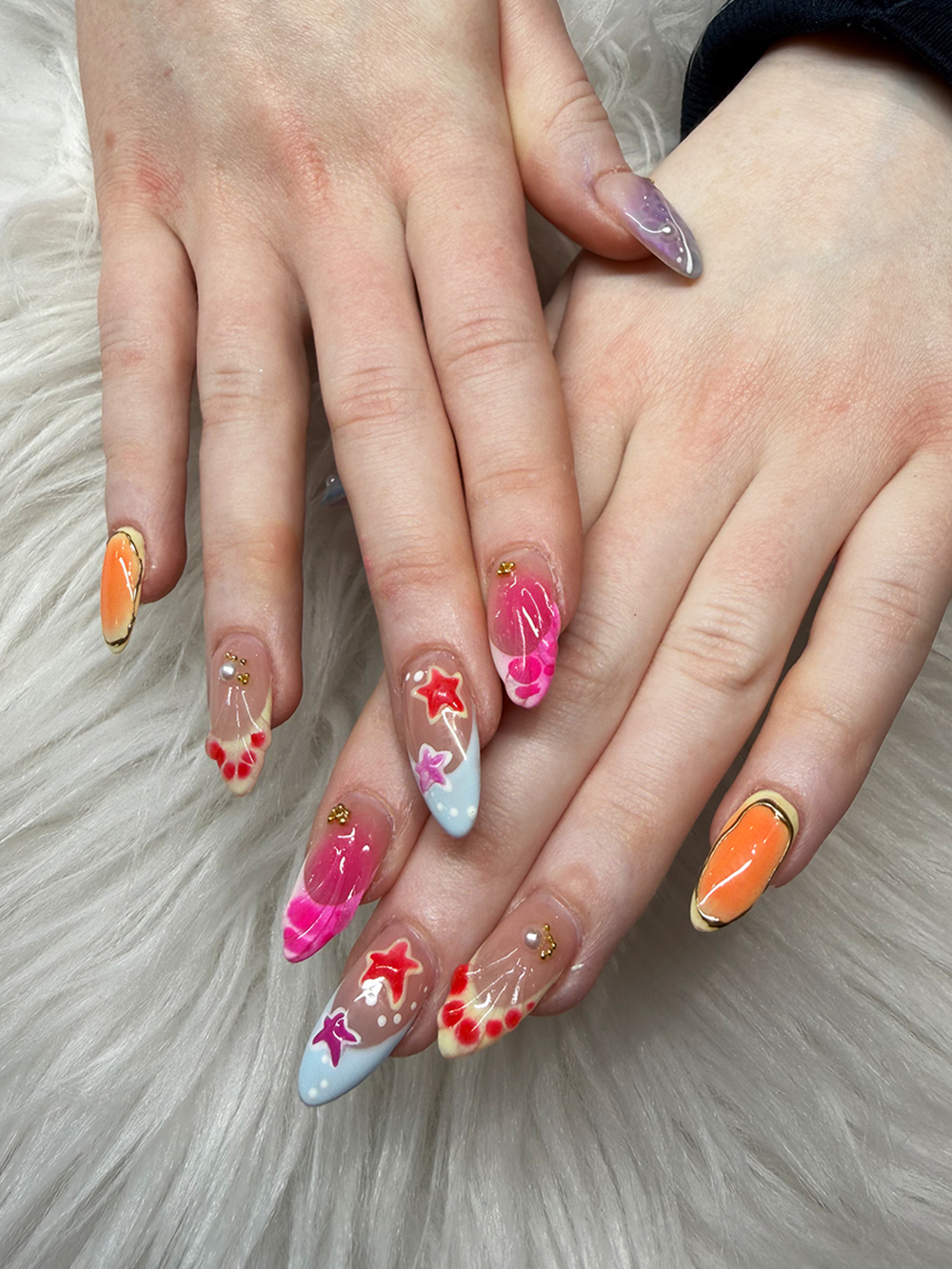 Colorful almond nails with pink waves, blue ocean tips, starfish and floral accents by Chic Nail and Head Spa